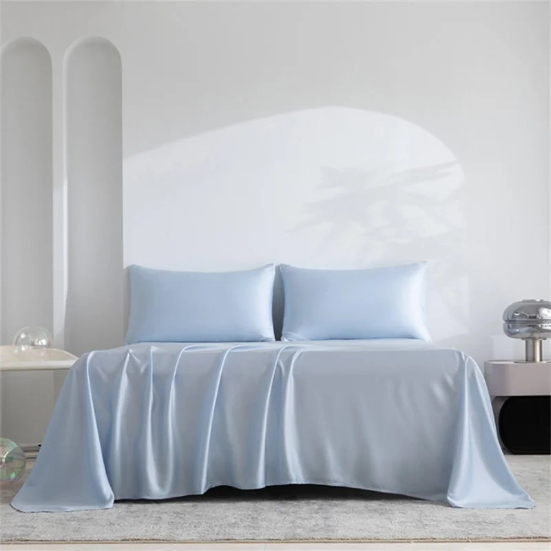 Light blue luxury organic bamboo bed sheet set draped over a bed.