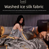 A model is relaxing on a bed covered with a luxurious gray ice silk fabric blanket and pillows.