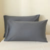 A set of two solid gray luxury polyester pillow covers resting on a white surface.