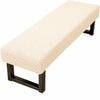 A beige jacquard stretch bench cover with a woven pattern supported by a black wooden frame.