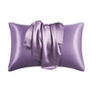 A purple satin silk pillow cover with a gathered fabric detail.
