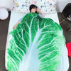 A person is lying on a white bed with a green leafy blanket throw.