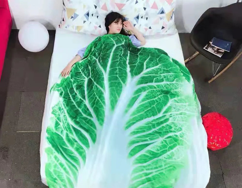 A person is lying on a white bed with a green leafy blanket throw.