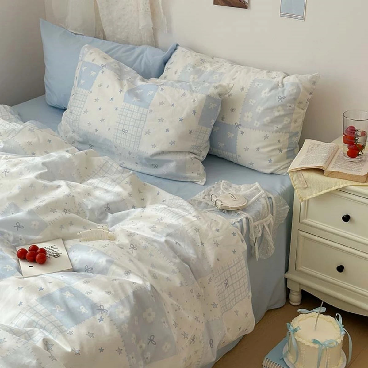 A set of three light blue floral duvet covers and pillowcases displayed on a bed.