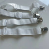 White adjustable bed sheet grippers and fasteners laid out on a white surface.