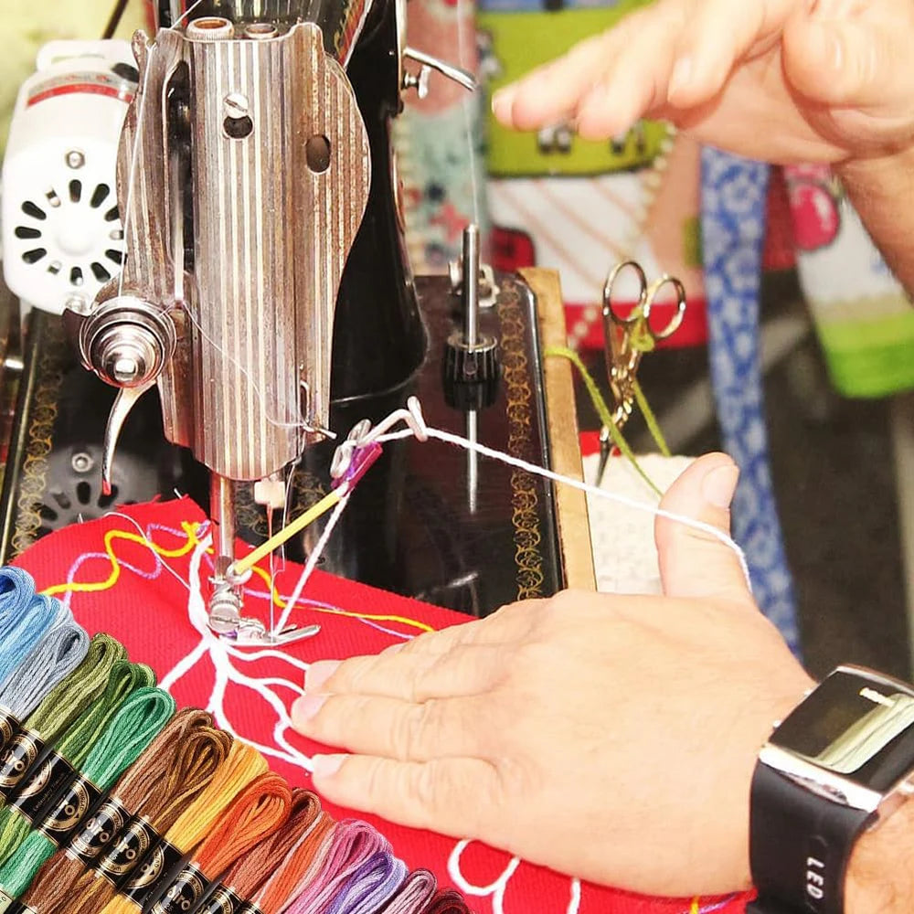Hands are shown working on a gradient cross stitch embroidery thread set with colorful threads and a sewing machine.