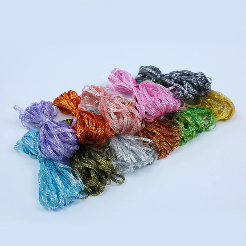 A collection of 10-meter gold and silver glitter satin ribbon in various colors, including pink, purple, green, and black.