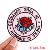 Pink embroidered iron-on patch with text and a red rose design on a pink background