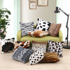 A set of two leopard print throw pillow covers in various shades and patterns displayed on a light green sofa.