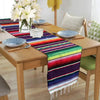 Colorful cotton Mexican sarape table runner displayed on a wooden table.