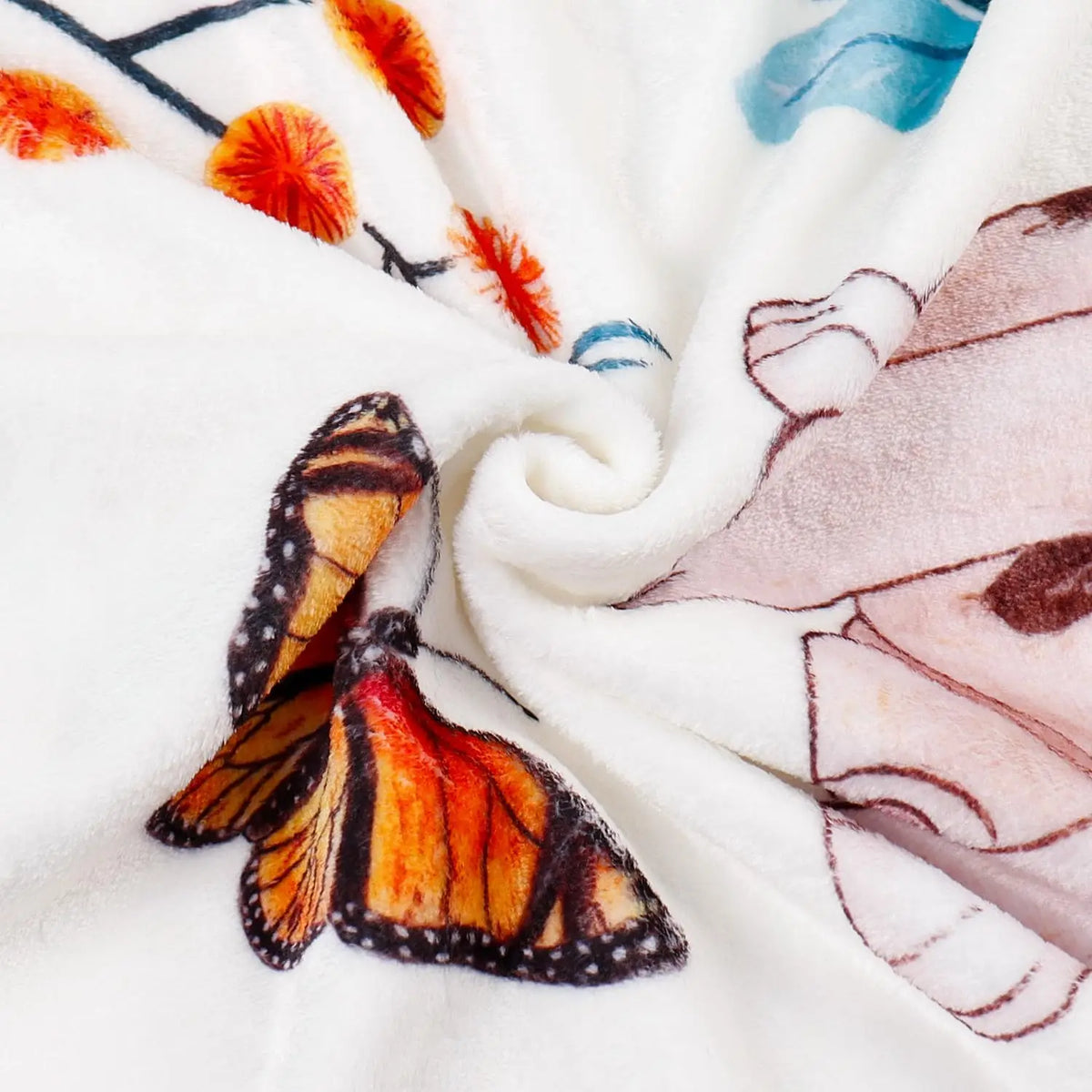 A close-up of a white flannel blanket featuring a watercolor pattern of orange and blue elements and a butterfly design.
