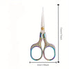 A pair of vintage stainless steel sewing scissors with decorative handles and a pointed blade.