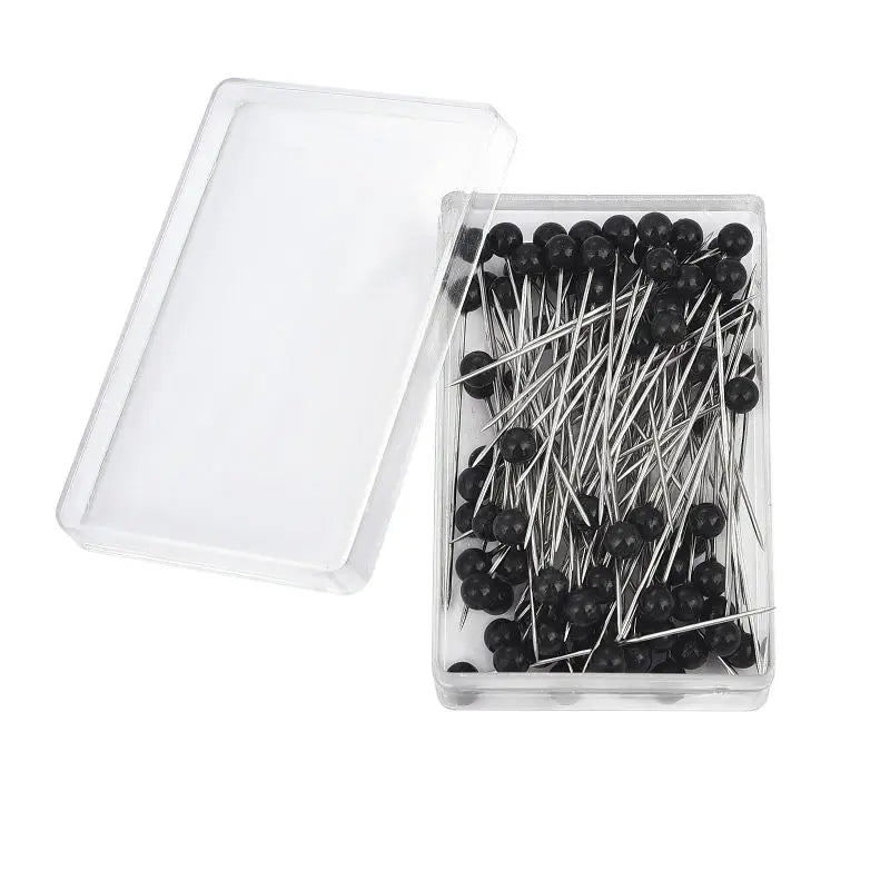 A clear plastic container holds a pack of 100 black pearl head sewing pins.