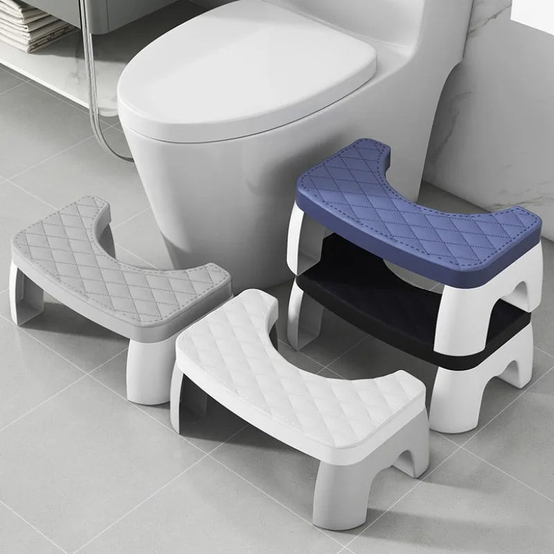 A set of white and blue adjustable adult toilet squat stools shown on a gray floor.