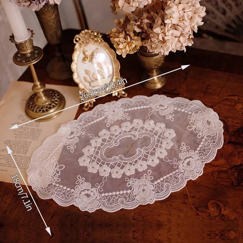 A set of elegant oval lace embroidered coasters displayed on a wooden surface with decorative elements.