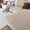 A beige removable jacquard seat cushion cover displayed on a light sofa with neutral pillows and a white rug.