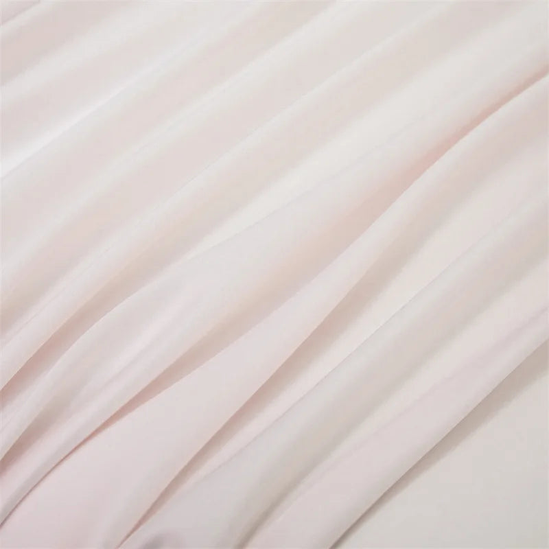 Soft pink luxury bamboo flat sheets draped in flowing fabric