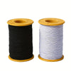 Spool of black and white elastic sewing thread on a yellow spool holder