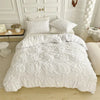 White pinch pleat duvet cover set displayed on a king size bed with white bedding and wooden flooring.