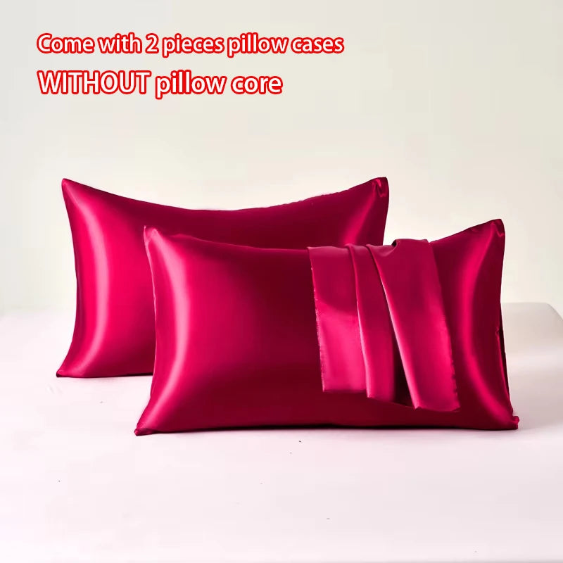 Two magenta satin pillow cases without a pillow core displayed on a white surface.