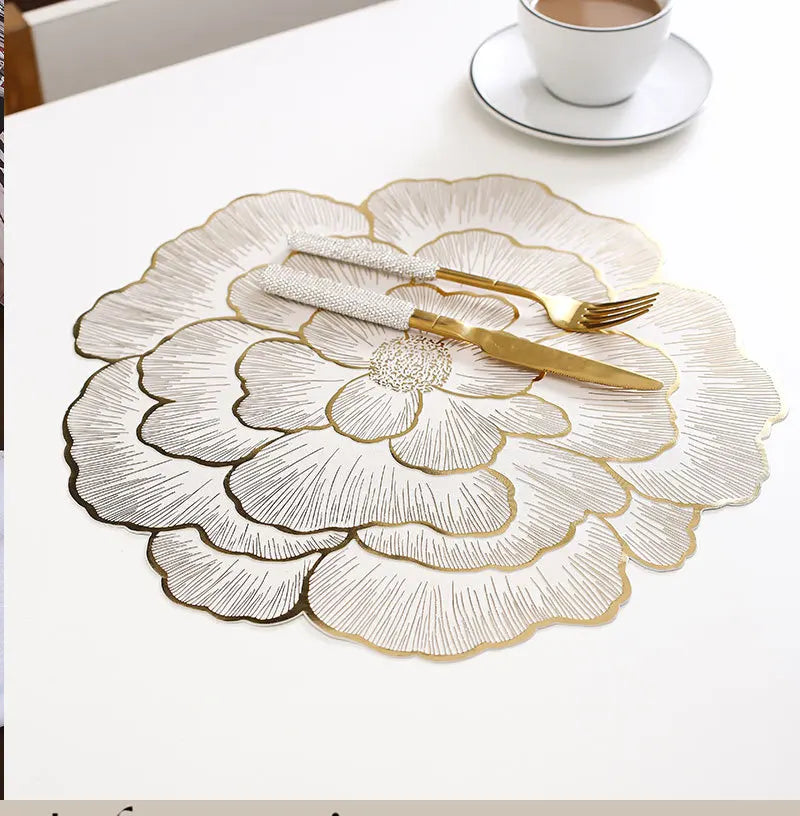 Gold plated peony coasters with delicate line art design on a white surface.