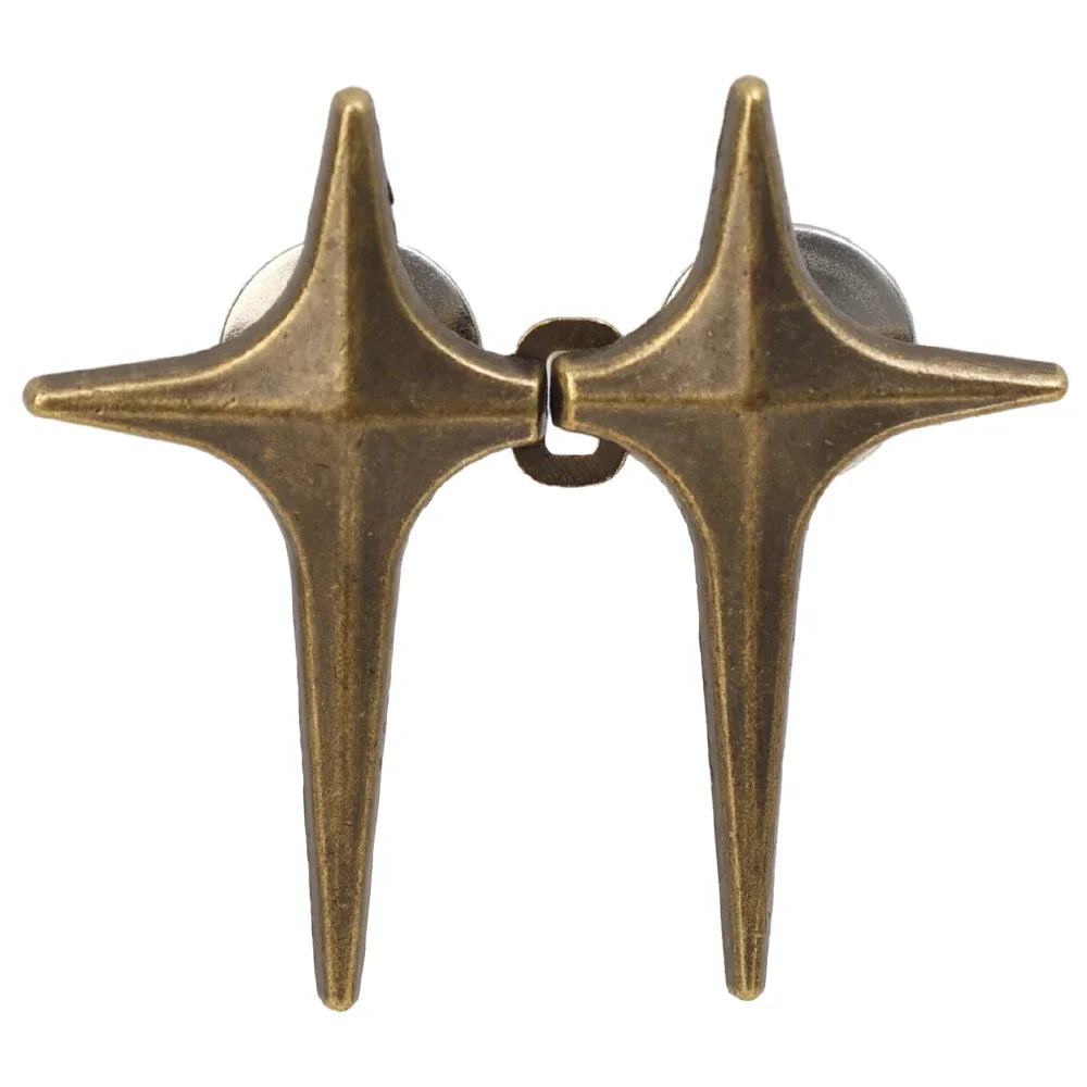 A pair of antique brass star-shaped jean buttons for clothing.