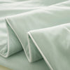 A folded light mint green ice silk cooling comforter fabric.