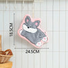 A pink felt hanging hand towel shaped like a cute cartoon grey and white dog.