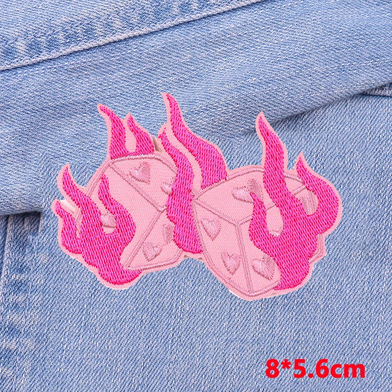 Pink embroidered letter patches shaped like flames on a denim fabric background