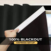 A hand is pulling a black and white blackout window curtain across a window frame.