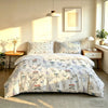A bed with a hand-painted floral duvet cover set displayed in a bright room.