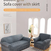 A gray stretch knit sofa cover with a skirt and bubble lattice texture displayed on a sofa.