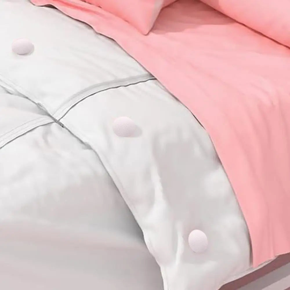 A close-up of a white duvet cover with pink fabric and small white clips on the corner.