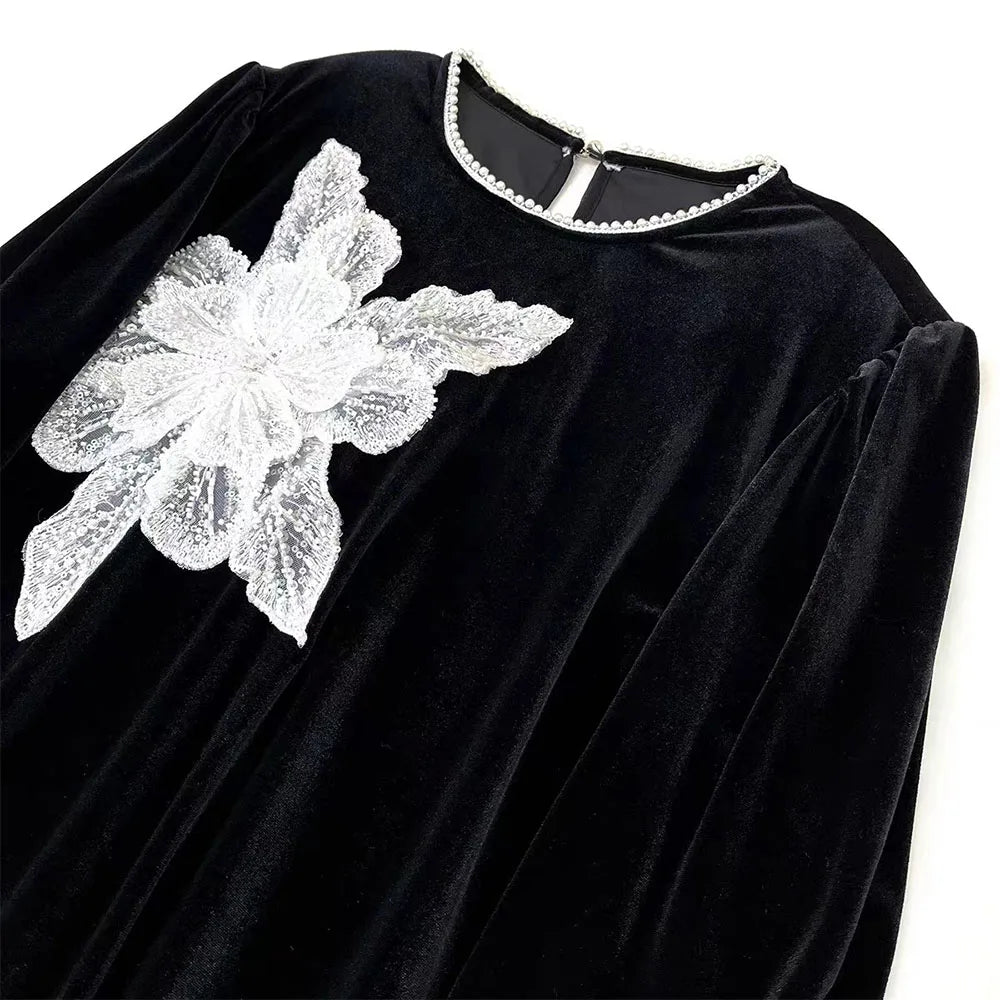 Black velvet fabric featuring a white floral sequin lace applique patch on the shoulder