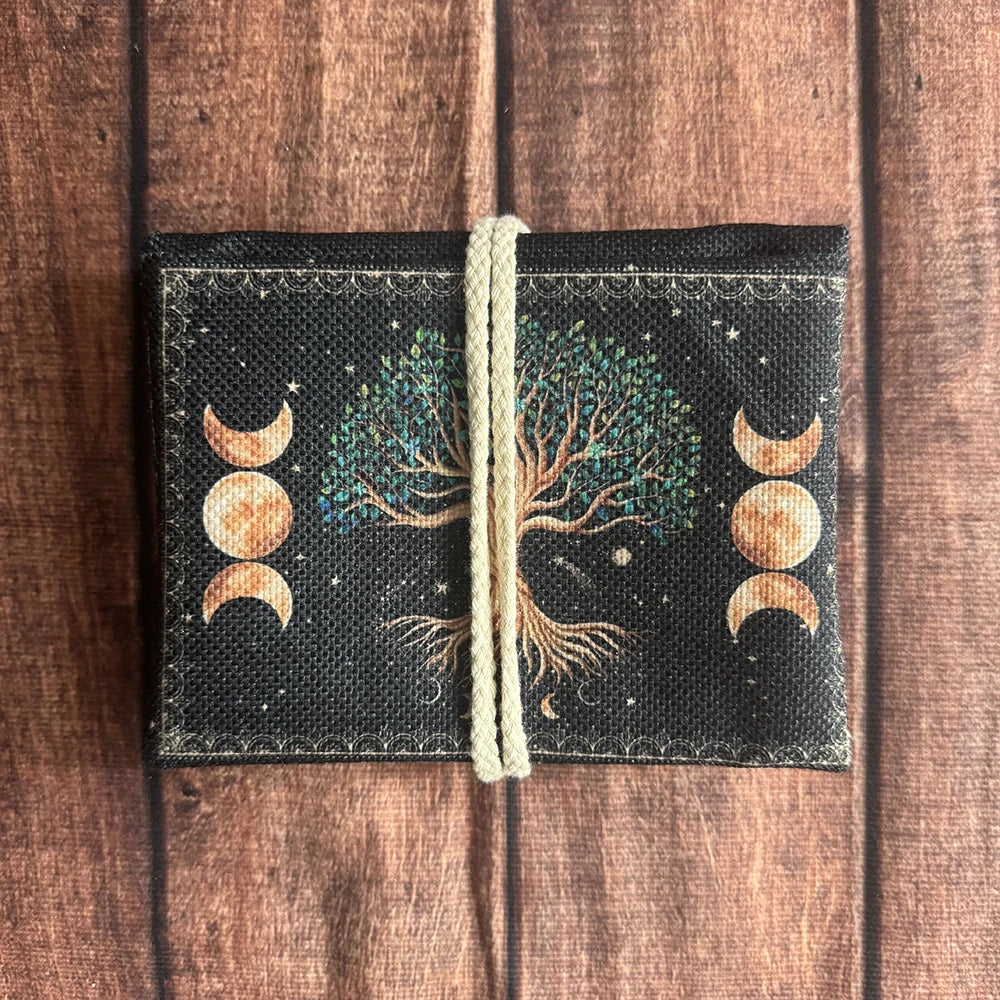 A black pouch with a woven cord closure featuring a tree silhouette and crescent moons.