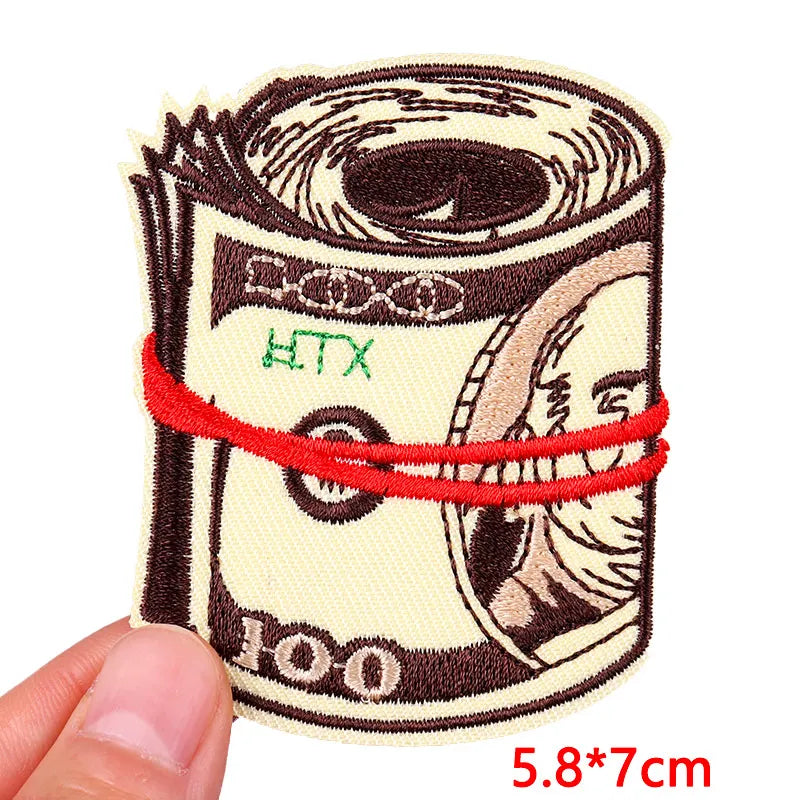 Embroidery patch depicting a rolled-up paper with a rose skull design in brown and cream colors.