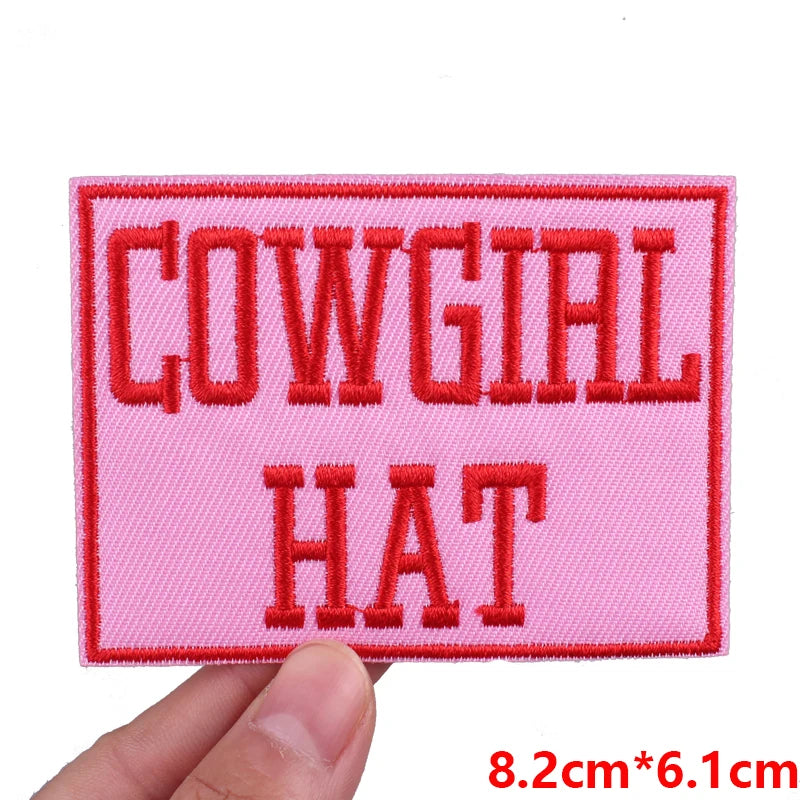 Pink embroidered patch with the text COWGIAL HAT