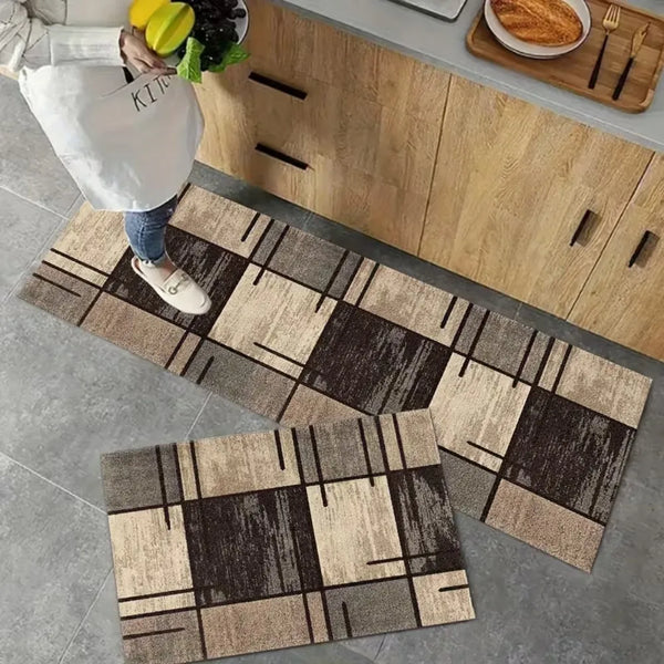 A modern checkered floor mat with brown and beige geometric patterns placed on a gray floor.