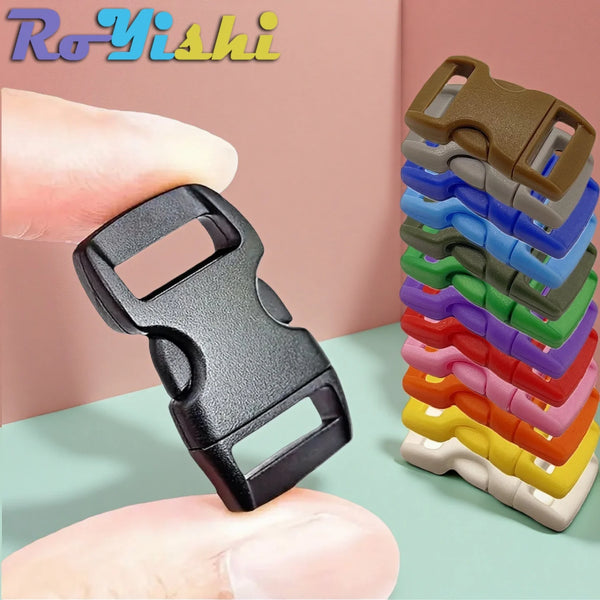 A hand holds a black adjustable plastic paracord buckle bracelet next to a stack of similar bracelets.