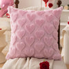 A pink heart embroidery plush cushion cover resting on a white surface.