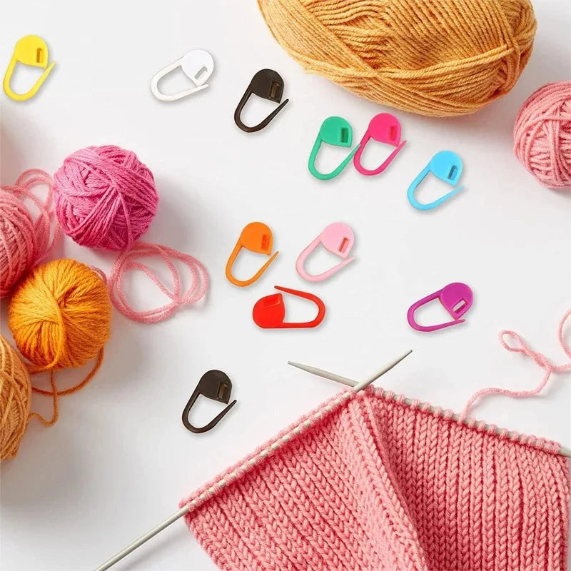 A collection of colorful stitch markers in various shapes and sizes for knitting and crochet projects.