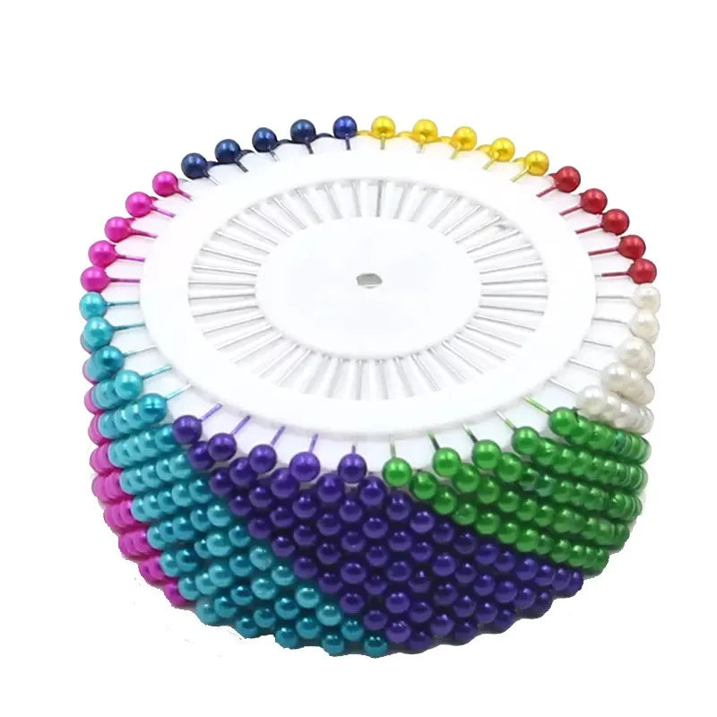 Colorful pearl straight head pins arranged in a circular pattern for crafting