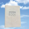 A beige book titled Stitch Book is shown against a bright blue sky with white clouds.