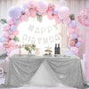 A silver sequin glitter tablecloth draped over a table for a birthday party setup decorated with pink and purple balloons.
