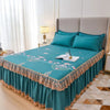 Teal floral bed skirt with lace trim protecting a mattress on a bed.