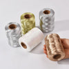 Rolls of glitter metallic yarn in silver and gold colors are displayed on a white surface.