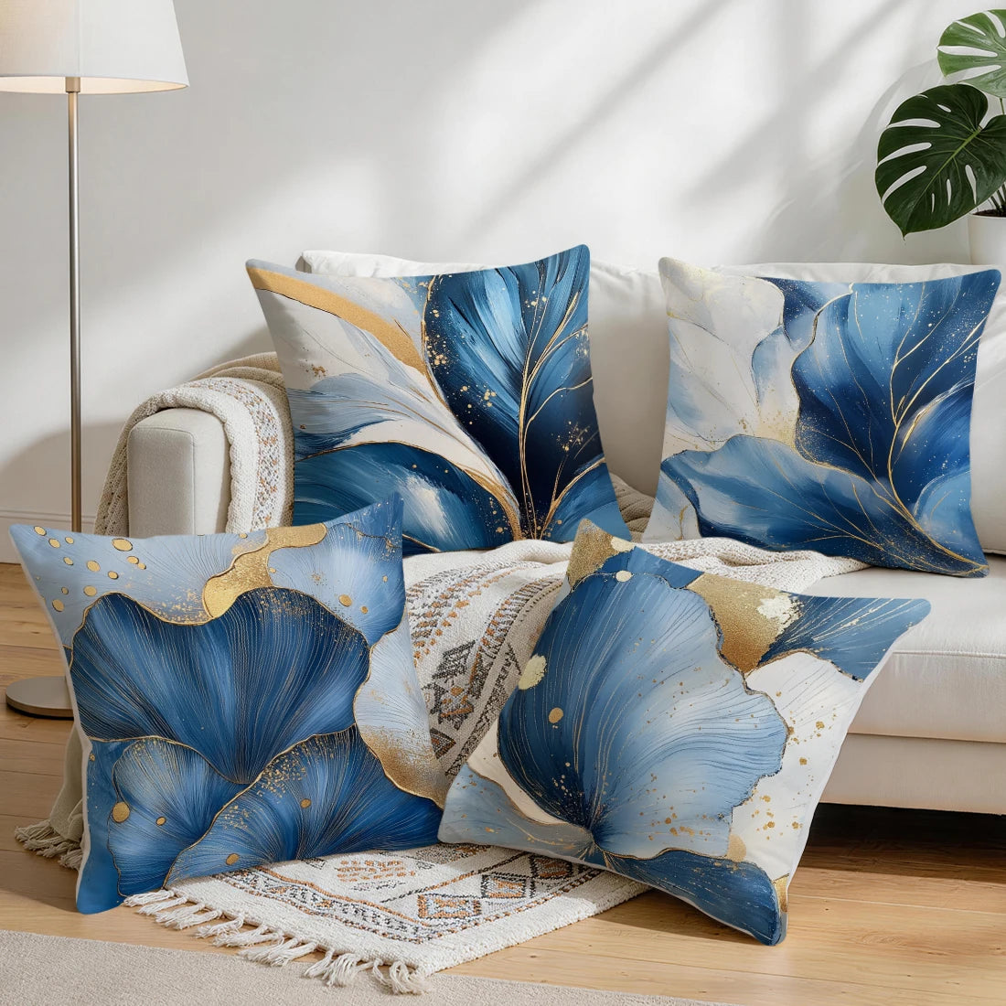 Blue and gold abstract leaf cushion pillow covers displayed on a sofa