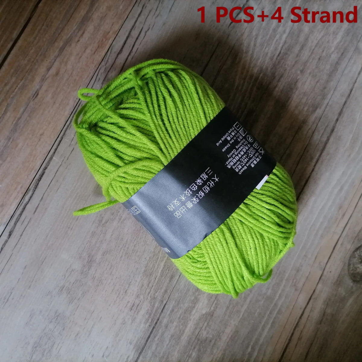 One ball of bright lime green organic cotton 4ply knitting yarn with four strands visible.