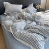 A plaid duvet cover and pillowcase set in blue and white checkered fabric with a decorative bunny pillow.