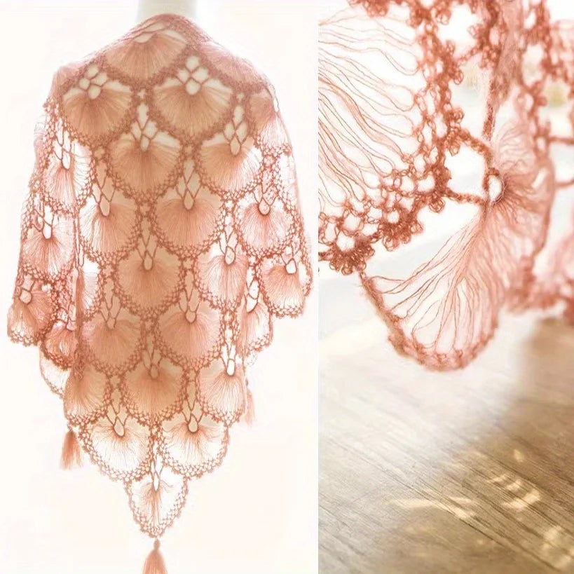 Close-up of a sheer, peach-colored lace fabric made from premium mohair yarn draped against a wooden surface.